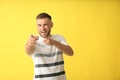 Handsome man pointing at viewer on color background Royalty Free Stock Photo