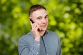 Handsome man portrait talking at the cell phone on green bokeh background