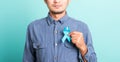 Handsome man posing he holding light blue ribbon for supporting people living Royalty Free Stock Photo