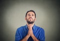 Handsome man praying hands clasped hoping for best asking for forgiveness Royalty Free Stock Photo