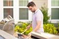 Handsome man preparing barbecue grill outdoor. Man cooking tasty food on barbecue grill at backyard. Chef preparing food Royalty Free Stock Photo