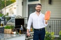 Handsome man preparing barbecue grill outdoor. Male chef cooking tasty salmon fillet on barbecue grill at backyard. Chef Royalty Free Stock Photo