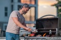 Handsome man preparing barbecue. Male cook cooking meat on barbecue grill. Guy cooking meat on barbecue for summer Royalty Free Stock Photo