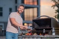 Handsome man preparing barbecue. Male cook cooking meat on barbecue grill. Guy cooking meat on barbecue for summer Royalty Free Stock Photo