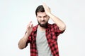 Handsome man pressing hands to head and clenching teeth panicking being in perplexed situation Royalty Free Stock Photo