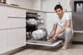 handsome man putting detergent tablet into dishwasher Royalty Free Stock Photo