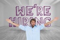 Handsome man raising arms in front of were hiring graphic