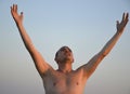 handsome man in the rays of the setting sun raised his hands and head up Royalty Free Stock Photo