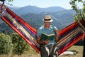 Handsome man reading book in hammock outdoors on sunny day Royalty Free Stock Photo