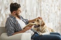 Handsome man reading book to his pet at home Royalty Free Stock Photo