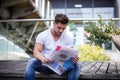 Handsome man reading newspaper outdoor in city Royalty Free Stock Photo