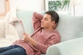 Handsome man reading newspaper on sofa at home Royalty Free Stock Photo