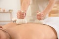 Handsome man receiving herbal bag massage in spa salon Royalty Free Stock Photo