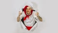 A handsome man with red dreadlocks holds it in his hand milk. Confident young cook in white apron and red tie holding a Royalty Free Stock Photo