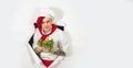 A handsome man with red dreadlocks holds it in his hand milk. Confident young cook in white apron and red tie holding a Royalty Free Stock Photo