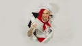 A handsome man with red dreadlocks holds it in his hand milk. Confident young cook in white apron and red tie holding a Royalty Free Stock Photo