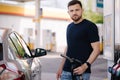 Handsome man refuelling his car on self service gas station. Male filling diesel at gasoline fuel Royalty Free Stock Photo