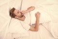 Handsome man relaxing in bed. Snoring can increase risk headaches. Common symptom of sleep apnea. Causes of early