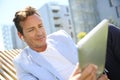 Handsome man relaxing outdoors with tablet Royalty Free Stock Photo