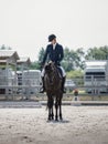 Handsome man rider on black stallion horse greets during equestrian competition in daytime in summer Royalty Free Stock Photo