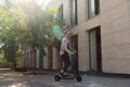 Handsome Man Riding Modern Kick Scooter At Cityscape Background. Contemporary Eco Transport