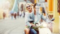 Handsome man riding a scooter with lauging girl