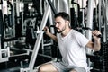 Handsome Man is Rowing Exercise With Bodybuilder Machine in Fitness Club. Sport Man Doing Workout Exercises Calories Burning in