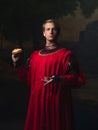 Handsome man in a Royal red doublet eating fast food.