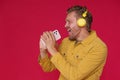 Handsome man 30s singing enjoying his favorite song or track using phone and wireless headphones wearing denim yellow Royalty Free Stock Photo