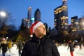 Handsome man in Santa Claus hat skating on rink Central Park on Christmas Eve. Crowds local people and tourists having fun in New Royalty Free Stock Photo