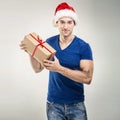 Handsome man in santa hat - hand gift box Royalty Free Stock Photo
