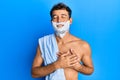 Handsome man saving beard with shave foam over face smiling with hands on chest with closed eyes and grateful gesture on face