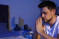 Handsome man saying bedtime prayer in dark room at night Royalty Free Stock Photo