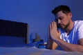 Handsome man saying bedtime prayer in dark room. Space for text Royalty Free Stock Photo