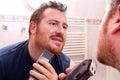 Handsome man shaving face with electric razor Royalty Free Stock Photo