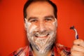 Handsome man with shaving foam on his face and razor Royalty Free Stock Photo