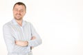 handsome man in shirt arms crossed and smiling while standing against white background Royalty Free Stock Photo