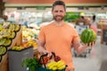 Handsome man with shopping basket with grocery. Man buying groceries in supermarket. Male model in shop. Concept of