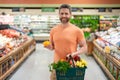 Handsome man with shopping basket with grocery. Man buying groceries in supermarket. Male model in shop. Concept of