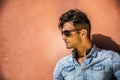 Handsome man sitting against orange wall