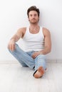 Handsome man sitting on floor by wall Royalty Free Stock Photo