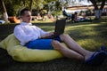 Handsome Man Sitting On The Grass In The City Working With A Laptop Royalty Free Stock Photo