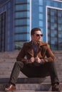 Handsome man is sitting on a skyscraper background Royalty Free Stock Photo