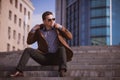 Handsome man is sitting on a skyscraper background Royalty Free Stock Photo