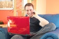 Handsome man sitting on sofa with phone and laptop Royalty Free Stock Photo