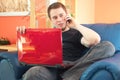 Handsome man sitting on sofa with phone and laptop Royalty Free Stock Photo