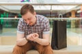 Handsome man sitting in store and looking at his watch Royalty Free Stock Photo