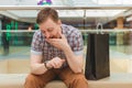 Handsome man sitting in store and looking at his watch Royalty Free Stock Photo