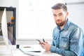 Handsome man sitting on workplace and using mobile phone Royalty Free Stock Photo