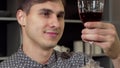 Handsome man smelling delicious red wine, relaxing at home Royalty Free Stock Photo